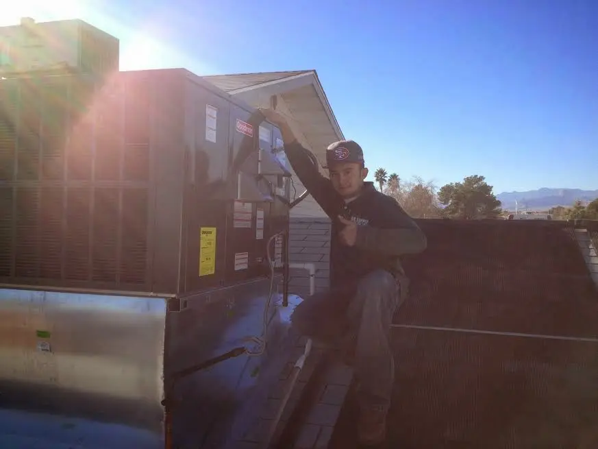 HVAC technician performing Heat Pump Repair on a rooftop unit in Blendon